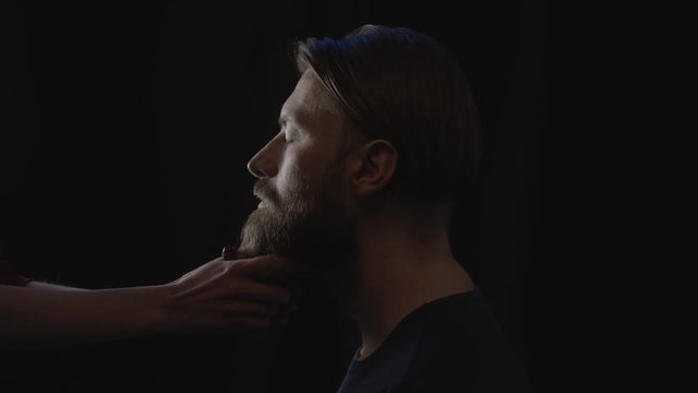 Hands of woman touching man's beard, slow motion