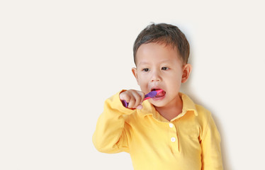 Portrait of little Asian baby boy brushing teeth on white background.