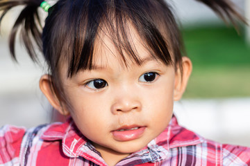 Portrait image of 1-2 years old baby. The little Asian child girl is ill with a runny nose. Close up face and head shot. Health care and kids concept.