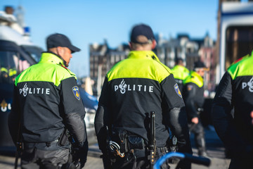 Dutch police squad formation and horseback riding mounted police back view with 
