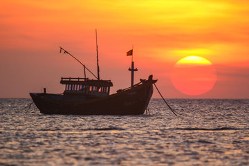 Fishing boat in the background of a huge sunset