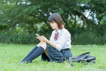 スマホを触る女子高生