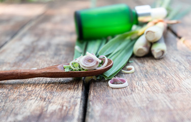 Fresh lemongrass with green bottle on wood table.