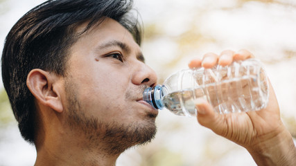 Fototapeta na wymiar Close up asian man drinking water outdoor