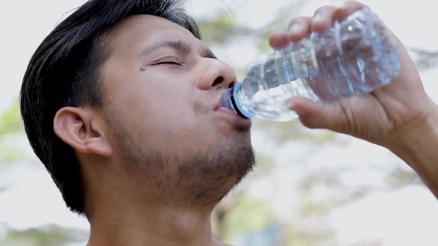 Close up asian man drinking water outdoor