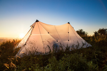 white tent in the steppe at sunrise