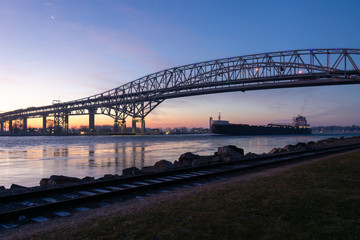 Freighter under the bridge at sunrise