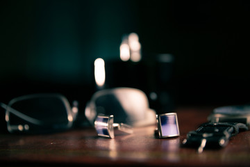 Mature man working at home as a watchmaker and jeweler composing an old clock using a screwdriver and a magnifying glass to be able to see closely