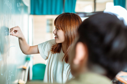 Group of students working on the mathematical problem in classroom