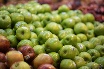red and green apples on display at market