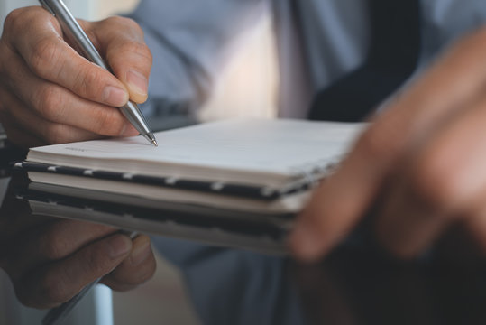 Businessman writing on notebook
