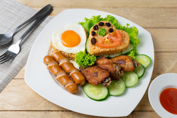 American fried rice with cucumber and lettuce in white dish on wooden table.