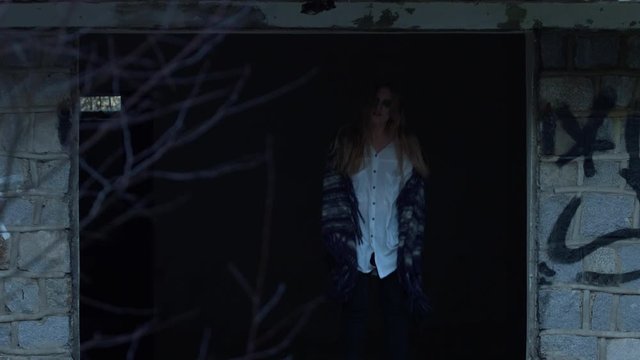 Slow motion jump of unhappy girl alone in lonely creepy ghost house,static wide shot