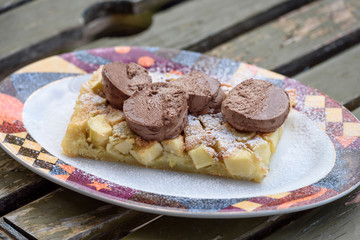 Pudding with apples and ice cream on beautiful plate.