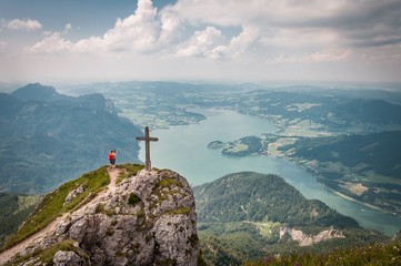 two people standing on the pinnacle of the Austrian mountain Schafberg with the lake Mondsee in the background