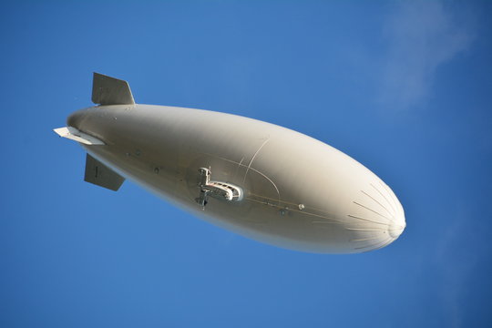 Low Angle View Of Blimp Against Clear Blue Sky