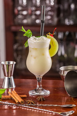 mai-tai coctail on a wooden stand. Bar accessories: shaker, spoon, spices on a wooden stand