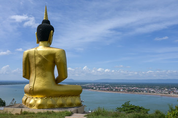 The big golden Buddha statue of Phu Salao temple with Mekong River flows through the Pakse city,Laos