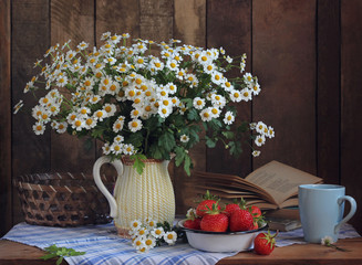 still life with a bouquet of daisies and ripe strawberries in a bowl