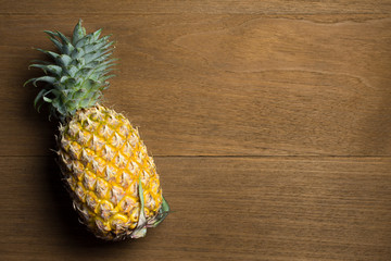 Ripe pineapple on wooden background.