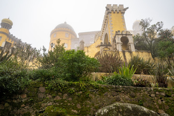 Fototapeta na wymiar Extremely foggy view of the famous yellow Pena Palace during winter
