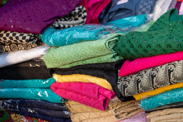 Selective focus on various fabrics for sale at a booth in Surajkund Crafts Mela in India