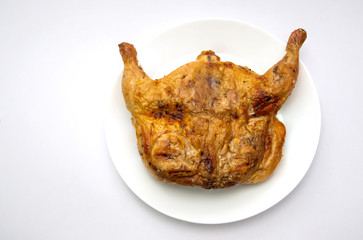 Tasty whole roasted chicken on white plate isolated on white