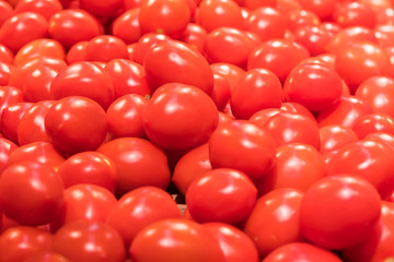 Vegetables are full of vitamins. Fresh and ripe tomatoes in a basket on a supermarket shelf. Ripe tomatoes in a supermarket
