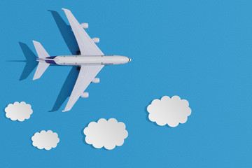 Miniature toy airplane on colorful paper background. Flat lay design of travel concept with plane and clouds on blue sky.