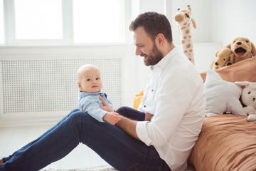 Fototapeta premium Happy father holding little baby son. Fatherhood and people concept