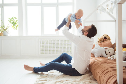 Happy Father Holding Little Baby Son. Fatherhood And People Concept