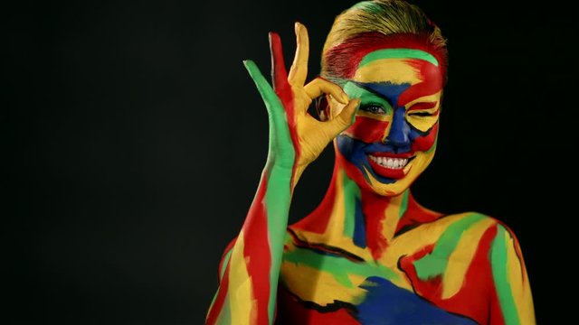 Woman with color face art and body paint. Colorful portrait of the girl with bright make-up and bodyart.