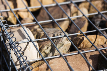 Gabion wall closeup. Textured background. stones in wire mesh used for to prevent erosion and slope reinforcement.