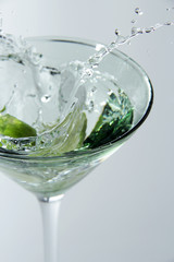 Splash from limes in a glass of cocktail, On the white background