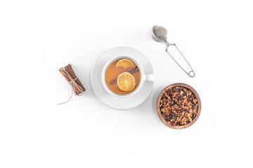 Fruit tea with cinnamon and dried orange in cup - teacup with strainer - filter isolated on white background