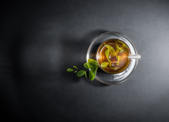 Mint tea leaves in a cup isolated on gray black background. Topview, above