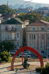 Bulgaria through the eyes of a tourist. Urban vertical landscape of two old four-story houses with tiled red and green roofs. Summer is a nice sunny day. Parked cars near the houses.