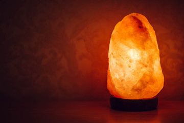 Salt lamp on the table in the room glows in the night