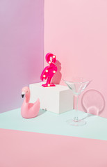 Summer party composition on a geometric background with pink flamingos and glass of cocktail. Beach or swimming pool concept