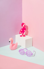 Plastic Flamingo night lights on a geometric background in Memphis style and twisted sunglasses.