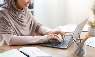 Smiling Arabic Woman Working On Laptop For New Project In Office