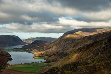 Majestic vibrant Autumn Fall landscape of Buttermere and Crummock Water flanked by mountain peaks of Haystacks High Stile and Mellbreak in Lake District