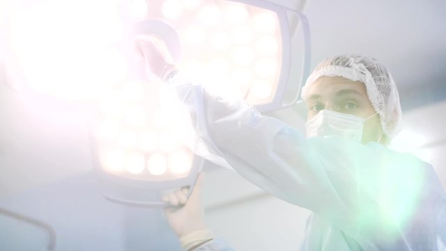 surgeon in the operating room turns on the light