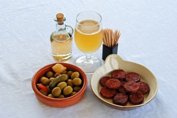 A selection of tapas with beer, Sliced Chorizo sausage and green olive cocktail, Spain.