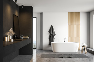 Black and white bathroom with tub and sink