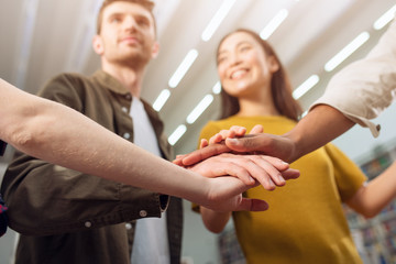 University Students put their hands together. Concept of teamwork and partnership