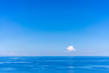 Obraz premium A single lonely cloud on a bright blue sky above the very calm lake titicaca, near Puno, Peru