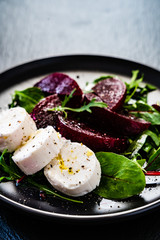  Beetroot salad with goat cheese on black stone plate