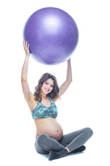 Portrait of a beautiful young pregnant woman exercises with fitball. Working out and fitness, pregnancy concept. Isolated white background.