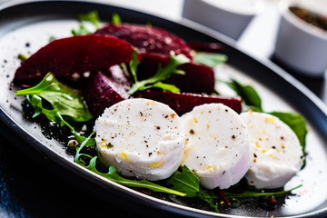  Beetroot salad with goat cheese on black stone plate